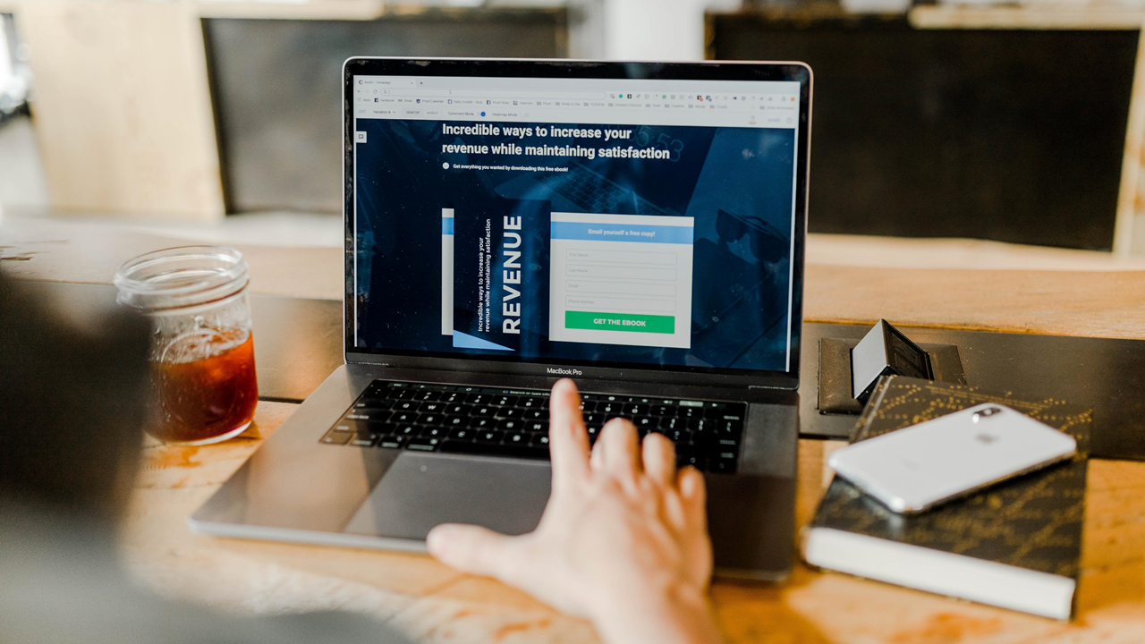 Man in front of laptop with landing page Man in front of laptop with landing page