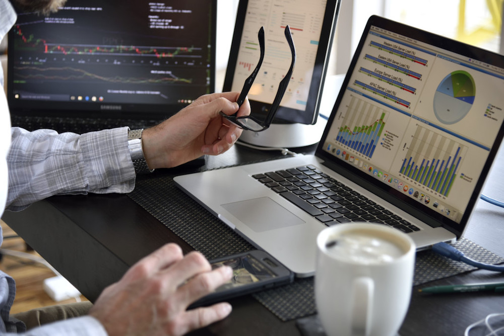 person-working-at-multi-computer-desk-with-many-screens-displaying-data-charts-and-graphs-information_t20_WQG0LY.jpg